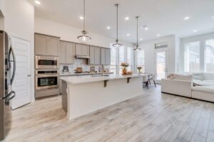 A family spending time together in a bright, spacious living area that combines kitchen, dining, and sitting spaces.